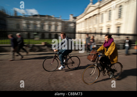 Cambridge University students cycle past the Senate House, Cambridge, England. October 2011 Stock Photo