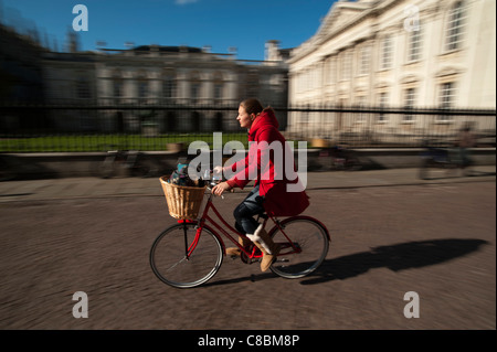 Cambridge University students cycle past the Senate House, Cambridge, England. October 2011 Stock Photo