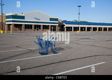 Warren, Michigan - A shopping cart is the only thing in a parking lot at a mostly-vacant shopping center, formerly anchored by Wal-Mart. Unemployment in Michigan is at 11.2 percent, above the national rate of 9.1 percent. Stock Photo