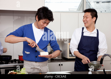 Two men cooking together in the kitchen Stock Photo