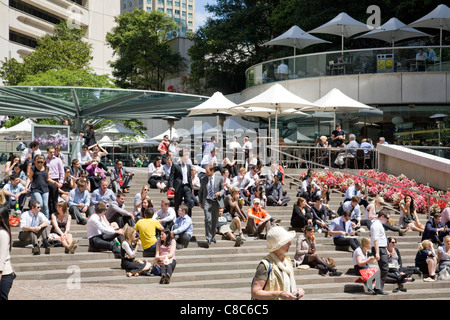 office workers sitting outside in sydney enjoying the summer weather Stock Photo