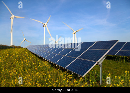 Solar panels and wind turbines in field Stock Photo
