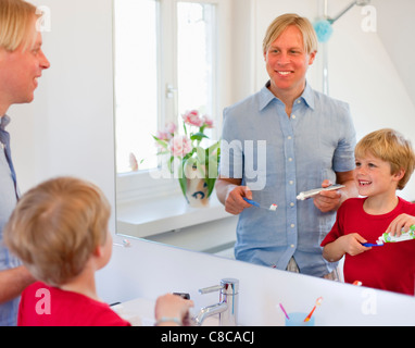 Father and son brushing their teeth Stock Photo