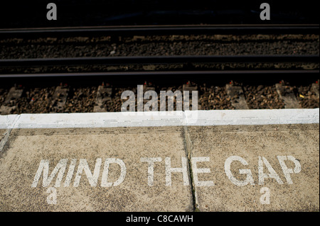 Mind the Gap warning painted on the edge of a railway platform Stock Photo