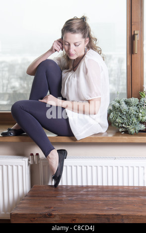 Woman talking on phone at windowsill