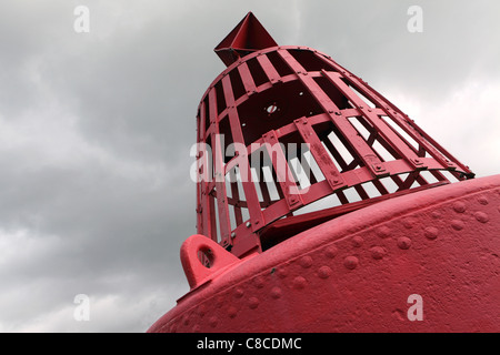 Port hand buoy (Red), marks the shipping channel, detail with gray sky behind, Harwich, Suffolk, UK Stock Photo