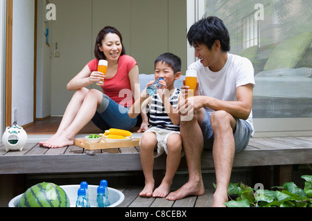 Family drinking at verandah Stock Photo