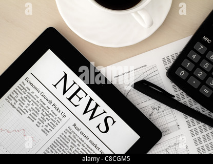 Desktop with a Tablet PC, which shows the latest news on screen. Stock Photo