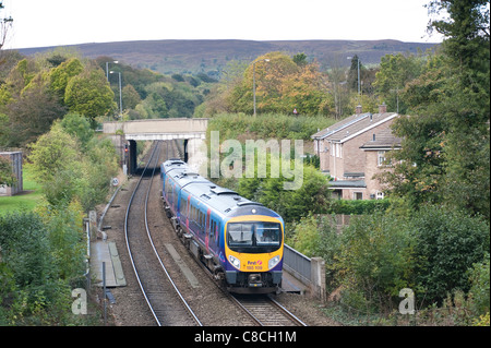 First Trans Pennine train passing by housing at Totley Rise in Sheffield travelling to Sheffield from Grindleford Stock Photo