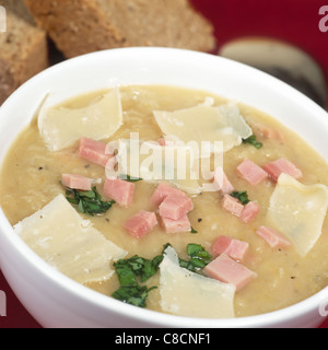 Bowl of leek soup with smoked ham and shaved cheese. Stock Photo