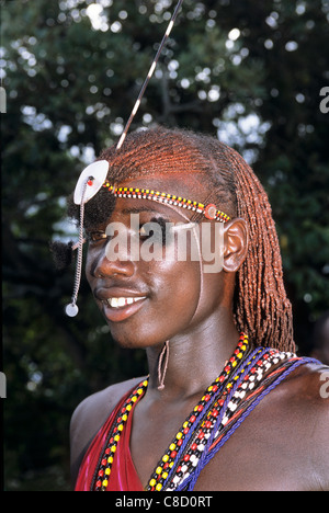 Lolgorian, Kenya. Siria Maasai Manyatta; moran with red ochre coloured braided hair with tufts, chain and shell decoration. Stock Photo