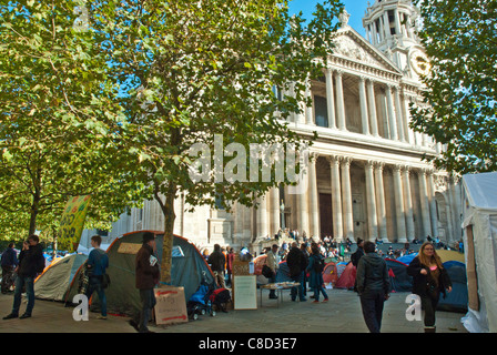 St Pauls, Occupy London, anti capitalist camp. Tents set up below the cathedral as people walk by. Blue sky. Stock Photo