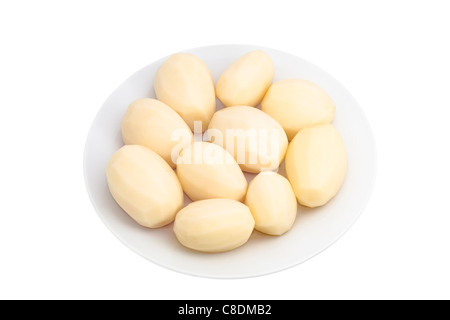 Peeled potatoes on plate, isolated on white background. Stock Photo