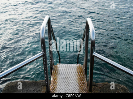 Steel steps leading to sea rock pool in Spain Stock Photo