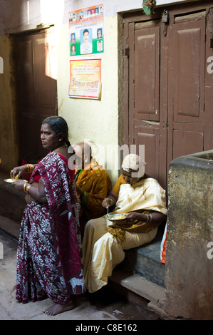 Indian people having lunch in an alleyway in the holy city of Varanasi, Benares, Northern India Stock Photo