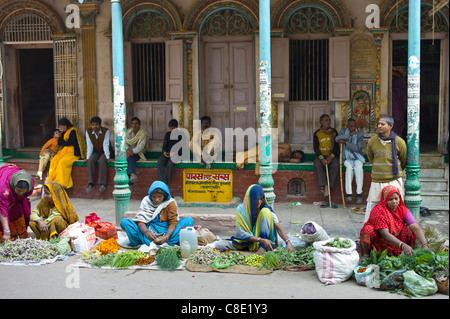 Women sell flowers and herbs for temple offerings by The Golden Temple in Festival of Shivaratri in holy city of Varanasi, India Stock Photo