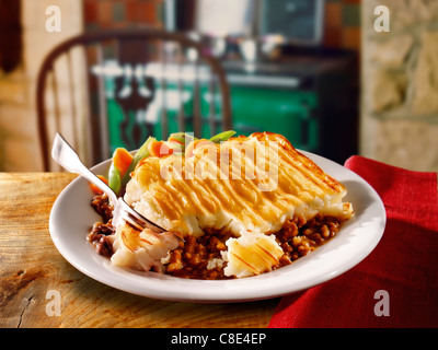 Traditional Shpeherd's potato pie, cooked and served on a white plate on a table setting in a kitchen, oven cooked minced lamb and mashed potato, Stock Photo
