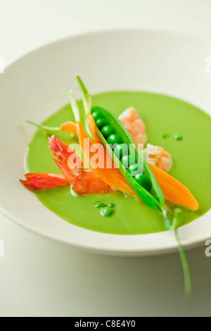 Cream of pea soup with shrimps Stock Photo