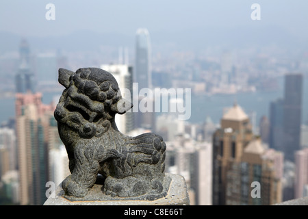 stone statue of Chinese dragon at The Peak, with view behind, overlooking Victoria Harbour & skyscrapers Hong Kong, China Stock Photo