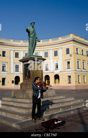 Ukraine, Odessa. Primorsky Boulevard, street musician playing violin in front of famous statue of Duke de Richelieu. Stock Photo