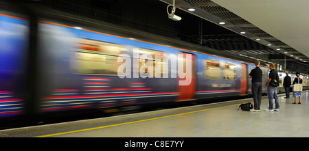 Motion blur of moving train & passengers on platform at St Pancras International low level railway station on Thameslink services London England UK Stock Photo