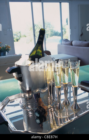 Glasses of Champagne and bottle of Champagne in an ice bucket Stock Photo
