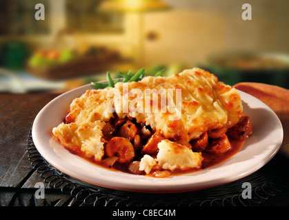 Traditional hot cooked British Cumberland potato and meat pie served on a plate in a kitchen setting ready to eat Stock Photo