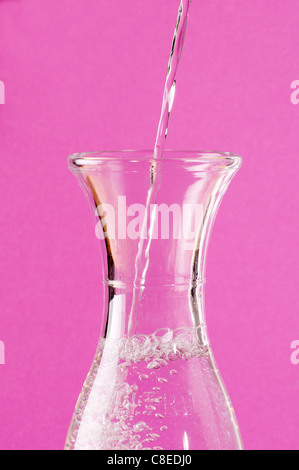 Pouring water into a glass jug Stock Photo