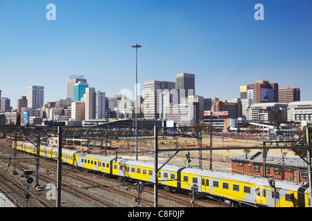 Train entering Park Station with city skyline in background, Johannesburg, Gauteng, South Africa Stock Photo