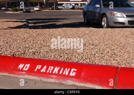 No parking sign painted on a red curb. Stock Photo