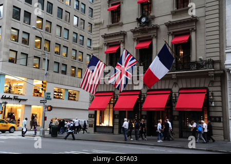 People walking front red canopy windows American French Union Flags, Cartier Store, 5th Avenue East 52nd Street, New York Stock Photo