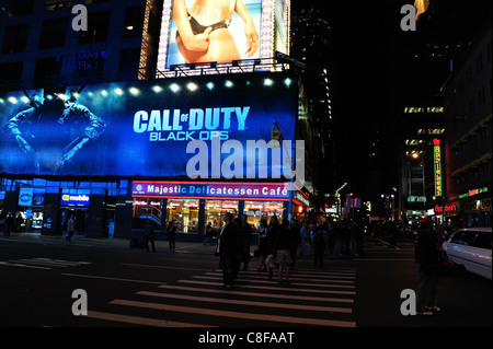 Night shot, man standing road people crossing front Majestic Cafe blue billboards, corner 7th Avenue West 50th Street, New York Stock Photo