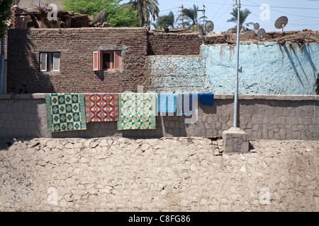 Traditional Egyptian houses with multi colour facades and multi coloured rugs hanging from the front wall, Egypt, Africa Stock Photo