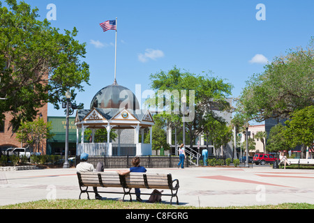 People sitting on benches near gazebo on the downtown square in Ocala Florida Stock Photo