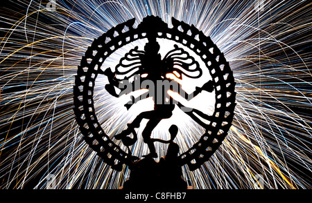 Dancing lord Shiva statue, Nataraja, in front of fireworks sparks. Silhouette Stock Photo