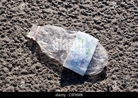 garbage plastic concept bottle flattened on asphalt street ground floor Stock Photo