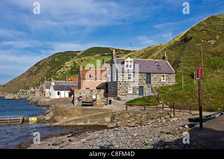 The former fishing village of Crovie in Aberdeenshire Scotland at Gamrie Bay with houses along the raised shore. Stock Photo