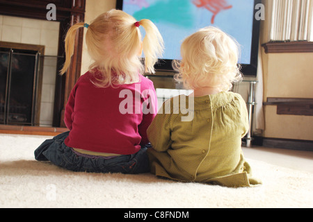 two sisters watching television together Stock Photo