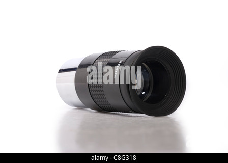 Close-up image of a black and metallic telescope eyepiece on a white background with a mild reflection/shadow beneath. Stock Photo