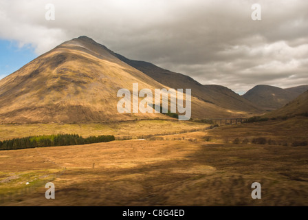 Scotland. Beinn Dorain munro, taken from West Highland Rail, dappled sunshine on hill and glen. Stock Photo