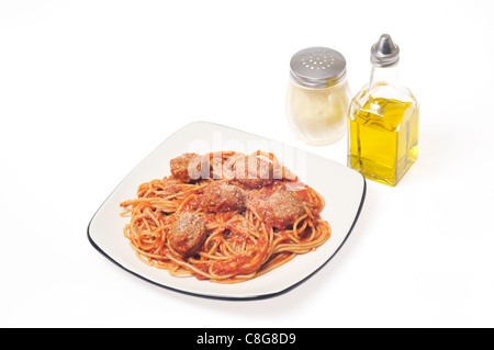 Cooked whole wheat spaghetti and meatballs with parmesan cheese on white plate on white background, cutout. Stock Photo