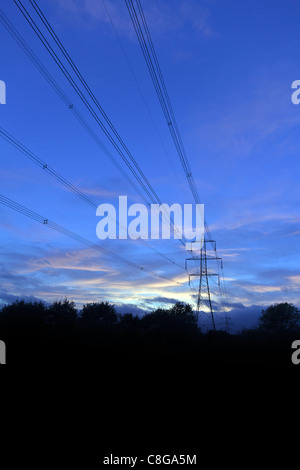 UK Pylon at dusk or dawn carrying  High Tension Electricity power supply cables Stock Photo