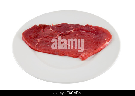 Raw beef schnitzel on white plate. Image is isolated on white background. Stock Photo