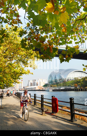 Cyclist on Quayside under The Tyne Bridge in Newcastle upon Tyne, England, UK Stock Photo