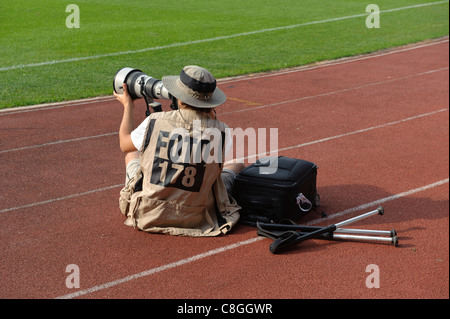 Professional photojournalist taking photos at sporting event Stock Photo