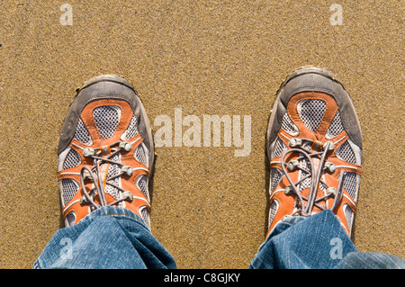 Looking down at a pair of mens feet in training shoes Stock Photo