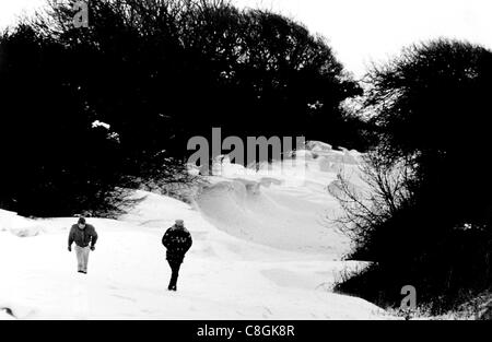 Two walkers trudge through the snow drifts along the Falmer Road near Brighton 1987 Stock Photo