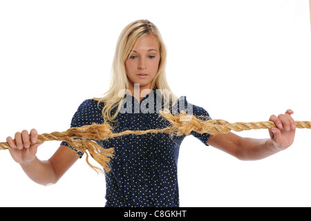 Young Businesswoman holding a rope that is about to brake isolated on a white background Stock Photo