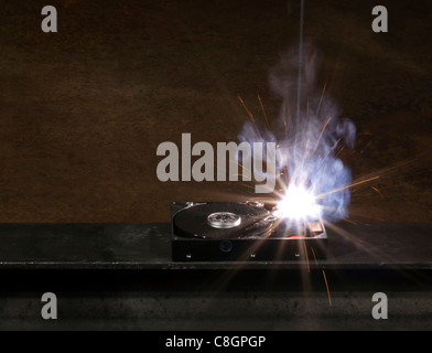 welding scenery with hard disk drive, welding mask detail and flying sparks Stock Photo