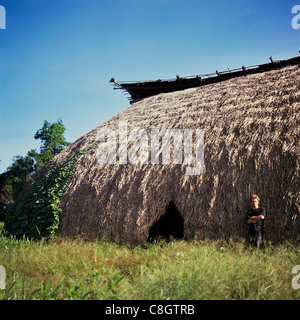 Pavuru Village, Brazil. Sting standing outside a large malloca; Xingu Indigenous reserve, Para & Goias State. Stock Photo
